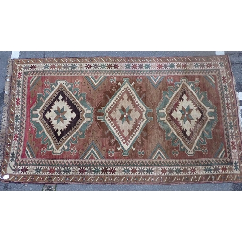 864 - A 20TH CENTURY KAZAK RUG woven in muted colours with endless repeat of lozenge medallions 250 x 140c... 