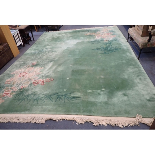 865 - LARGE GREEN CHINESE RUG with bamboo and camellias decoration, 303cm x 430cm plus fringes