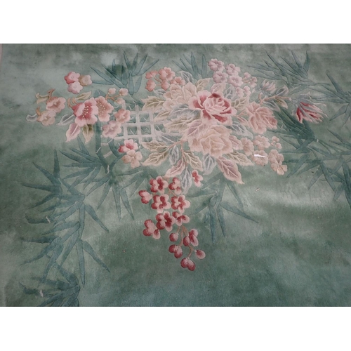 865 - LARGE GREEN CHINESE RUG with bamboo and camellias decoration, 303cm x 430cm plus fringes