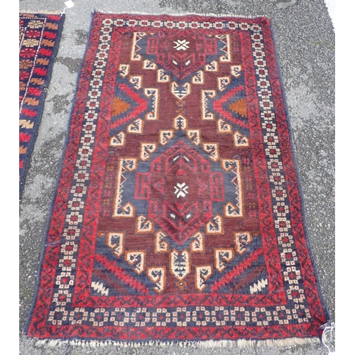 866 - TWO BELOUCHI RUGS EACH WITH LOZENGE MEDALLIONS 140 x 86cm and 136 x 80cm (both moth damaged) (2)