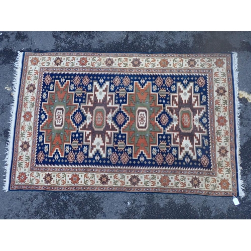 872 - AN ANATOLIAN RUG with four geometric medallions on a blue ground 188 x 122cm