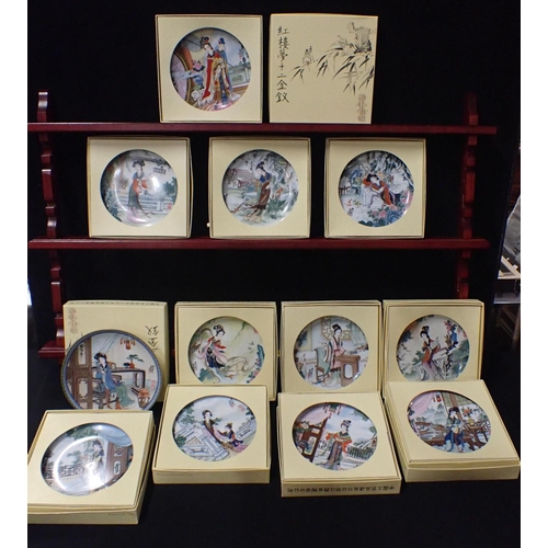 30 - A SET OF TWELVE 'BEAUTIES OF THE RED MANSION' PLATES boxed, with display rack