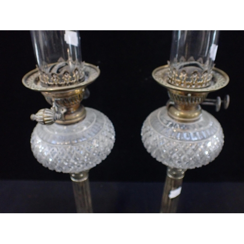 94 - A PAIR OF OIL 'PIANO LAMPS' with cut glass reservoirs and Evered's burners, set into a pair of silve... 