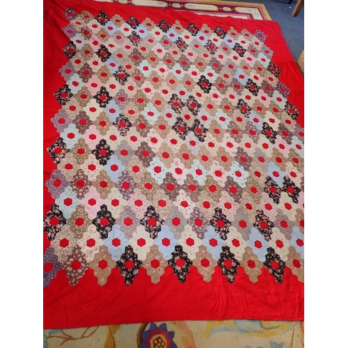 112 - AN OLD HEXAGON PATCHWORK QUILT on a red backing, 255 x 220cm approx (some damage), and a machine emb... 