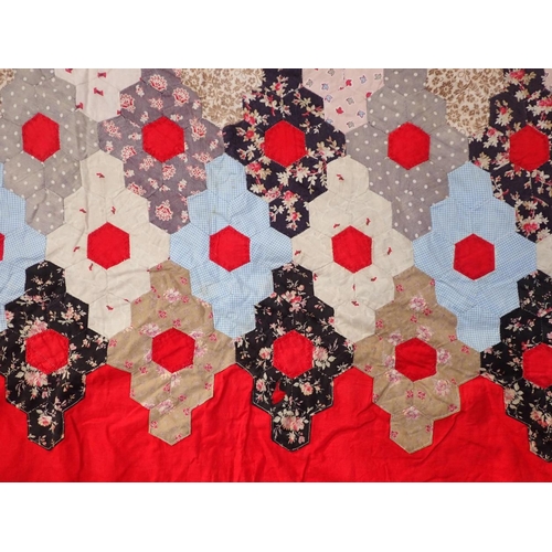 112 - AN OLD HEXAGON PATCHWORK QUILT on a red backing, 255 x 220cm approx (some damage), and a machine emb... 