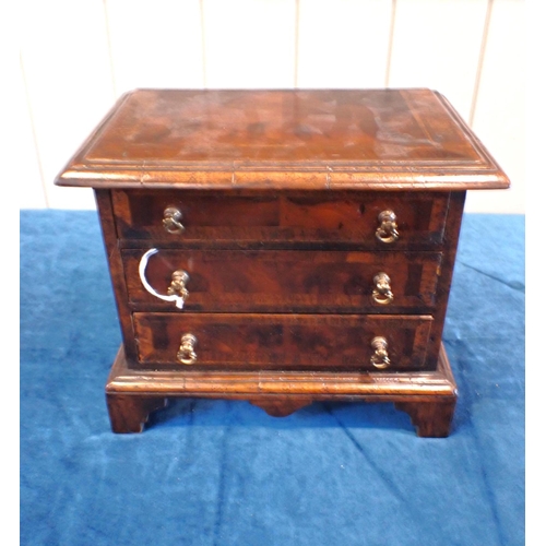 225 - AN EARLY 18th CENTURY STYLE WALNUT MINIATURE CHEST OF DRAWERS three drawers with brass ring handles,... 