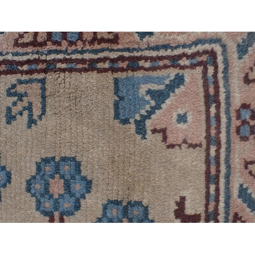 742 - A USHAK RUG woven in blue and brown with endless floral repeat on a mushroom ground, 174 x 96cm (wea... 