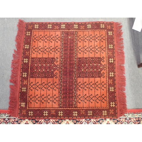 745 - TWO SIMILAR RED GROUND MACHINE MADE RUGS 119 x 169cm, and another smaller rug 85 x 85cm plus fringes... 