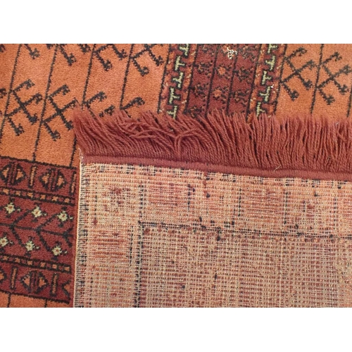 745 - TWO SIMILAR RED GROUND MACHINE MADE RUGS 119 x 169cm, and another smaller rug 85 x 85cm plus fringes... 