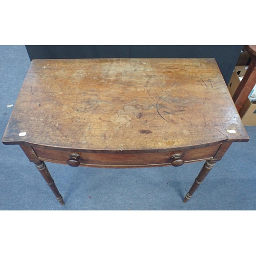 750 - AN EARLY 19TH CENTURY MAHOGANY BOW FRONTED SIDE TABLE fitted a frieze drawer with turned knobs, on s... 