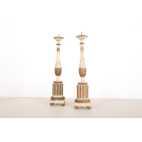 19 - THREE  ITALIAN WHITE-PAINTED AND PARCEL GILT PRICKET CANDLESTICKS

carved and gilded with fluted col... 