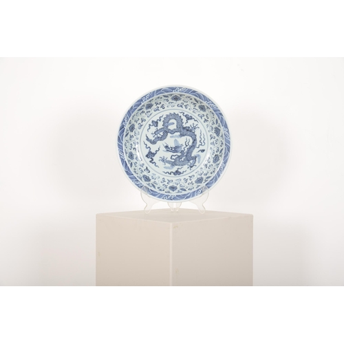 143 - A CHINESE BLUE AND WHITE DRAGON DISH

the body decorated with an imperial dragon, the sides with chr... 