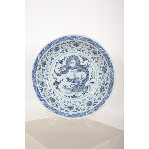 143 - A CHINESE BLUE AND WHITE DRAGON DISH

the body decorated with an imperial dragon, the sides with chr... 