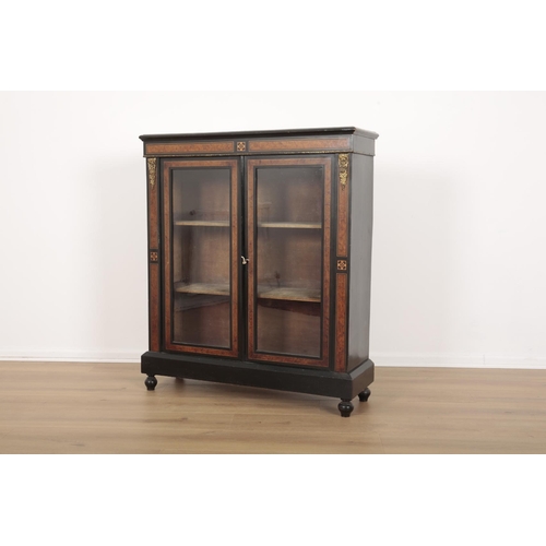 198 - A VICTORIAN EBONISED AND WALNUT BOOKCASE

with glazed doors opening to a shelved interior, on turned... 