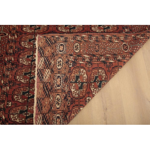 64 - AN ANTIQUE TEKKE TURKMAN RUG

woven in blue, white and orange with three rows of nine guls, on a red... 