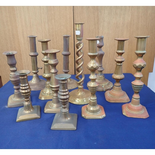 102 - A COLLECTION OF BRASS CANDLESTICKS four pairs and four singles, various styles