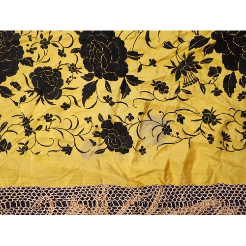 245 - A CHINESE SILK SHAWL, BLACK FLOWERS ON A YELLOW GROUND with long fringes (small pulls, marks), and a... 