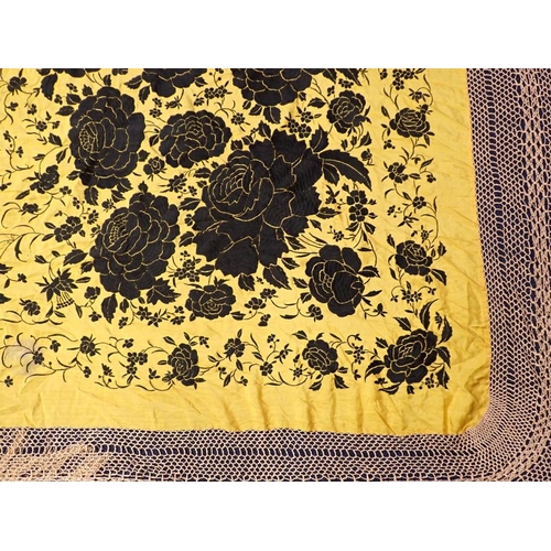 245 - A CHINESE SILK SHAWL, BLACK FLOWERS ON A YELLOW GROUND with long fringes (small pulls, marks), and a... 