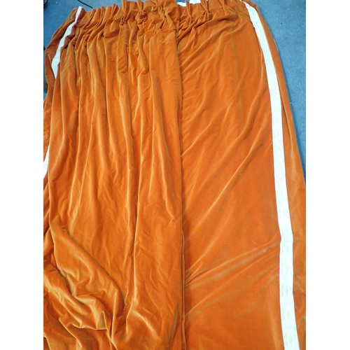 165 - A PAIR OF ORANGE VELVET CURTAINS, WITH PLEATED TOPS with applied border, lined and interlined 250cm ... 