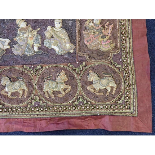 78 - A LARGE INDIAN EMBROIDERED WALL HANGING worked all over in relief with figures within panels, the ce... 