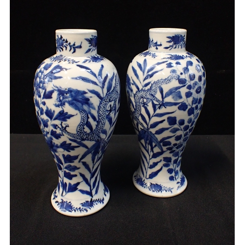 317 - A PAIR OF BLUE AND WHITE VASES painted with dragons, 27cm high (both a/f)