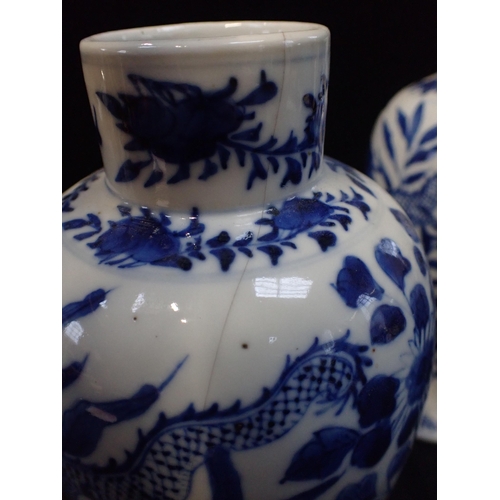 317 - A PAIR OF BLUE AND WHITE VASES painted with dragons, 27cm high (both a/f)