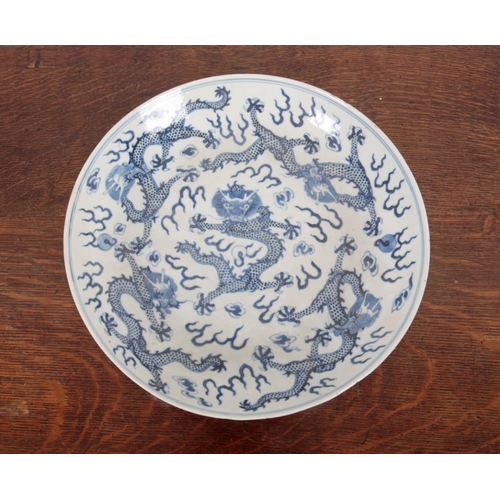 332 - A CHINESE PORCELAIN BLUE AND WHITE 'DRAGON' DISH bearing a six character Kangxi mark but later, Qing... 