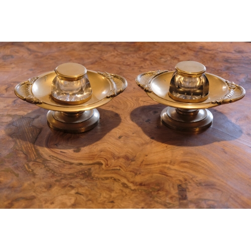 160 - A PAIR OF REGENCY STYLE CUT GLASS AND BRASS MOUNTED INKWELLS

the faceted wells with hinged lids, on... 