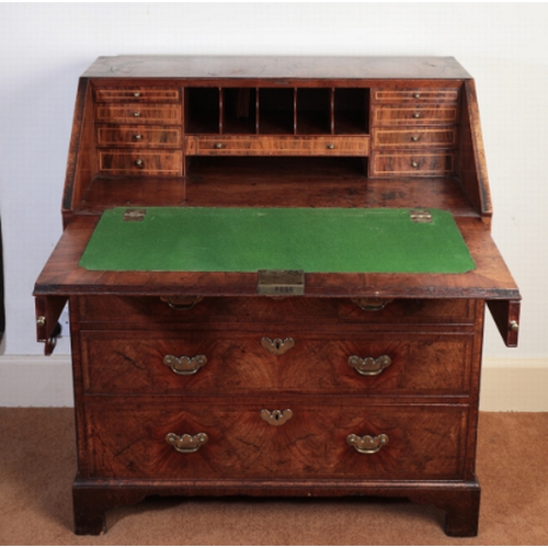 166 - A GEORGE I WALNUT BUREAU

with crossbanding and herringbone banding, the fall flap enclosing a fitte... 