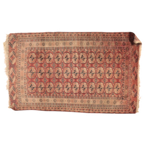 61 - A BOKHARA RUG

with a brick red field containing three rows of guhls within multiple foliate borders... 