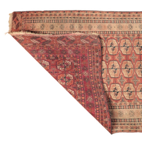 61 - A BOKHARA RUG

with a brick red field containing three rows of guhls within multiple foliate borders... 