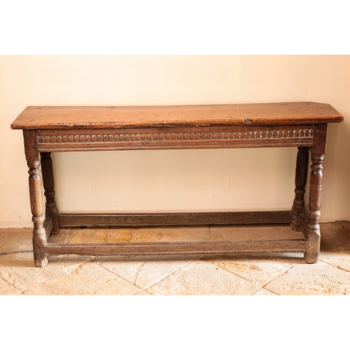 9 - A CHARLES II OAK LONG STOOL

with a rectangular fruitwood top over a moulded and carved seat rail, o... 