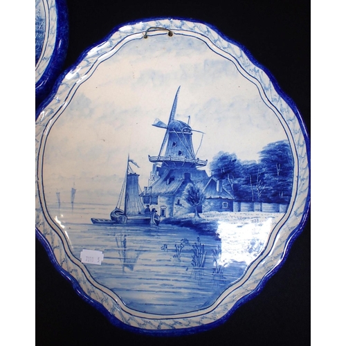 14 - A PAIR OF DELFT STYLE BLUE AND WHITE PLAQUES of cartouche form, decorated with canal scenes within m... 