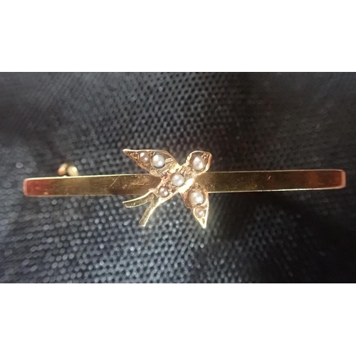 480 - AN ANTIQUE SEED PEARL SWALLOW BROOCH in 9ct yellow gold, along with two bar brooches in gilt metal, ... 