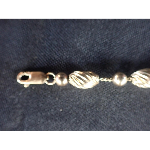 492 - A GOLD FILLED STYLISED BRACELET comprising a series of whorled fluted beads