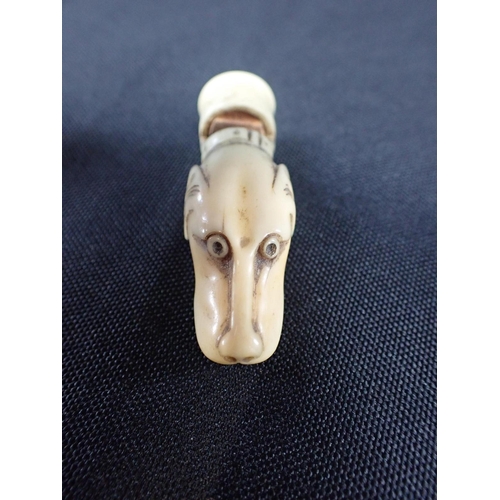 547 - A CARVED BONE WHISTLE, IN THE FORM OF A DOG'S HEAD 5.5cm long