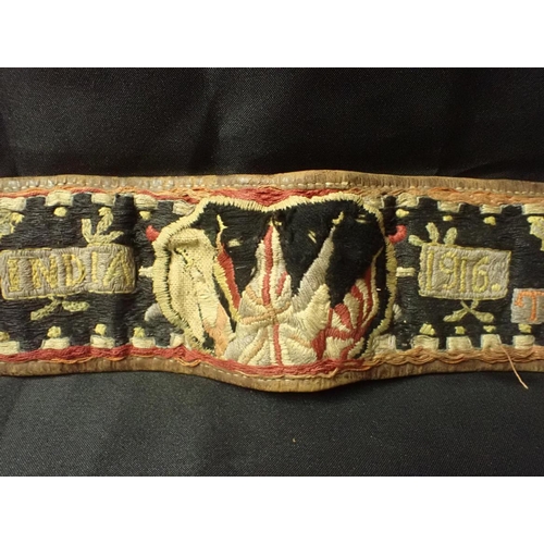 578 - A FIRST WORLD WAR EMBROIDERED BELT: 'INDIA' worked with motifs, flags of the Allies and date '1916' ... 