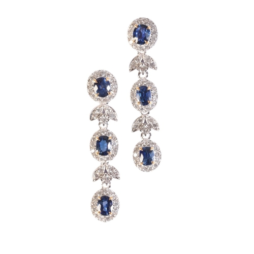 182 - A PAIR OF SAPPHIRE AND DIAMOND DROP EARRINGS

in 18ct white gold, each comprising a stylised row of ... 