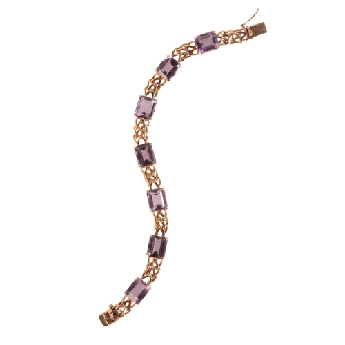 236 - A VINTAGE AMETHYST BRACELET

in 18ct gold, comprising a series of stylised links, set throughout wit... 
