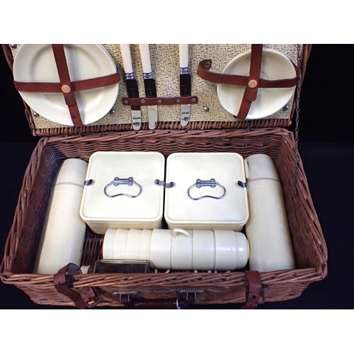 26 - A 'CORACLE' 1960S PICNIC SET with 'Bandalasta' ware contents, in a wicker basket