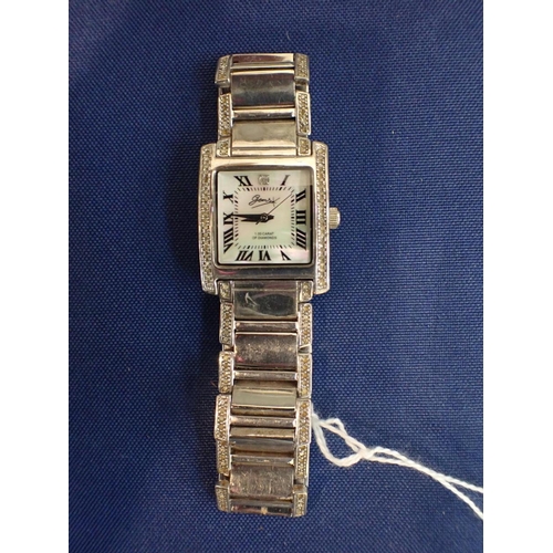 515 - A SILVER CASED GEM SET WATCH with mother of pearl dial and stainless steel bracelet