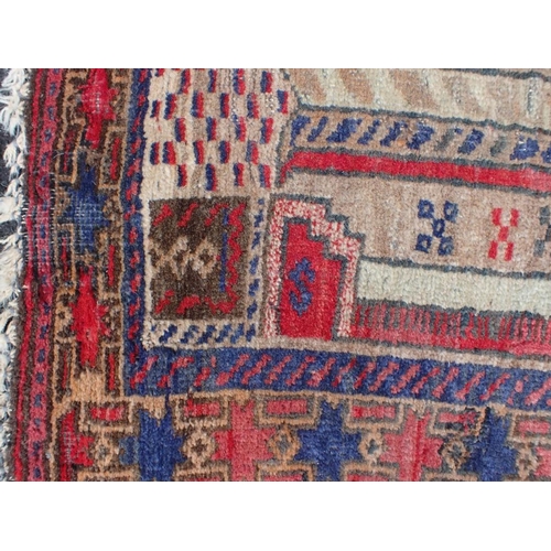 793 - A BELOUCH PRAYER RUG with architectural motifs worked in reds and blue, 83 x 160cm (moth damaged)