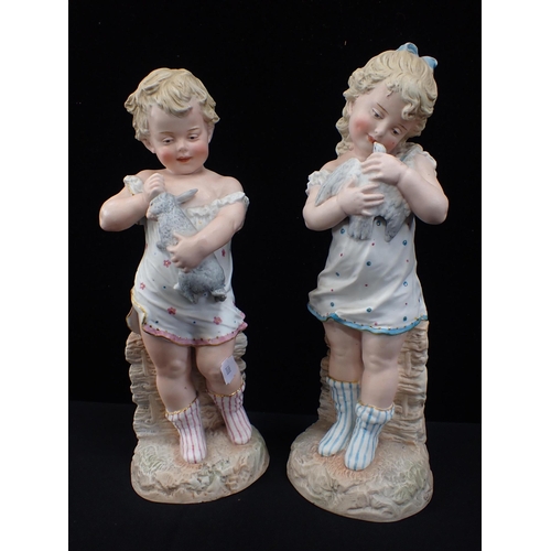 82 - GEBRUDER HEUBACH: A PAIR OF BISQUE FIGURES, BOY AND GIRL the girl holding a dove, the boy a rabbit 3... 