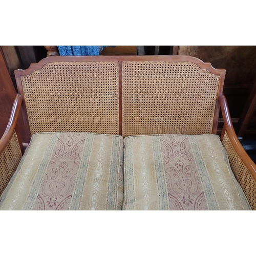 867 - A MAHOGANY FRAMED BERGERE SOFA two seat, with (intact) double-caned panels 137cm wide