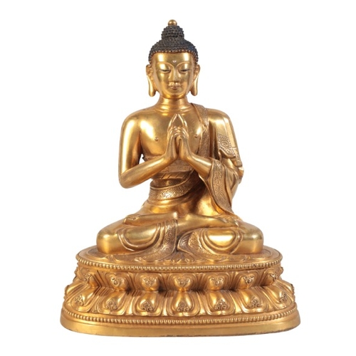 10 - A CHINESE GILT-BRONZE BUDDHA

seated in dhyanasana with his hands folded in uttarabodhi mudra, with ... 