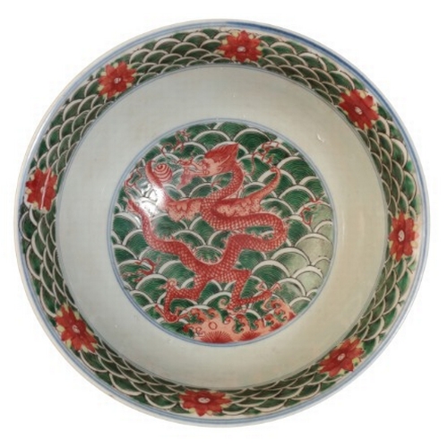 100 - A CHINESE FAMILLE VERTE DRAGON BOWL

bearing a Qianlong mark, 18th century or later, with writhing d... 