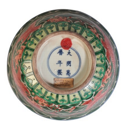 100 - A CHINESE FAMILLE VERTE DRAGON BOWL

bearing a Qianlong mark, 18th century or later, with writhing d... 