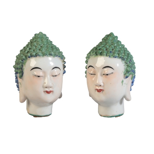 135 - A PAIR OF CHINESE HEADS OF BUDDHA

Qing, with tightly curled hair highlighted in bright blue and gre... 