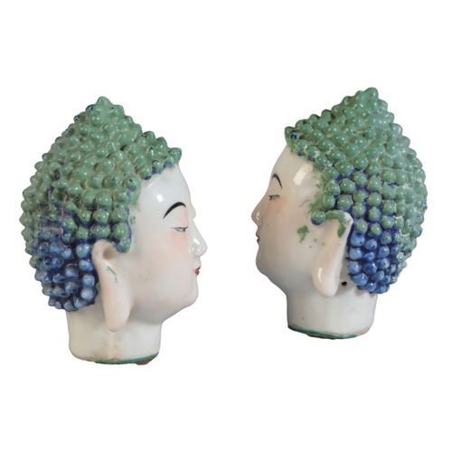 135 - A PAIR OF CHINESE HEADS OF BUDDHA

Qing, with tightly curled hair highlighted in bright blue and gre... 