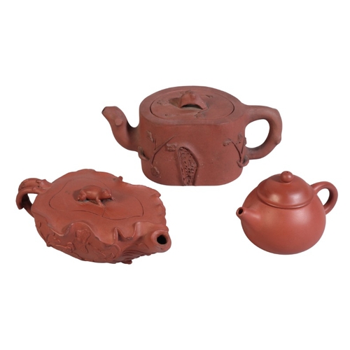 203 - THREE CHINESE YIXING TEAPOTS AND COVERS

19th century, one with frog finial on lotus shaped body dec... 